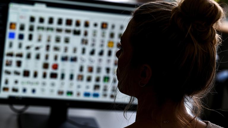 Eine Polizistin sitzt in einem Büro vor einem Auswertungscomputer (Symbolbild).