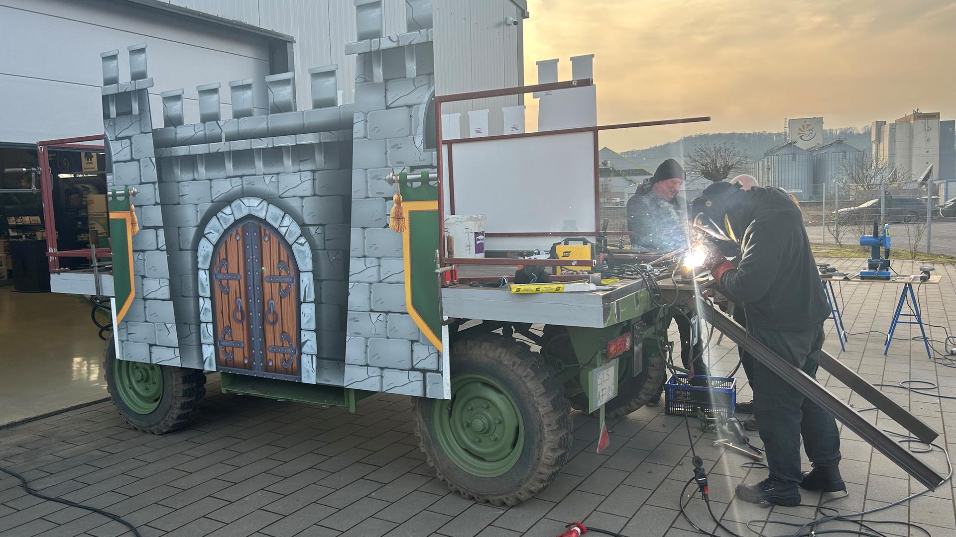 Die Mitglieder der KG Humor Merzig bauen ihren neuen Motivwagen um.