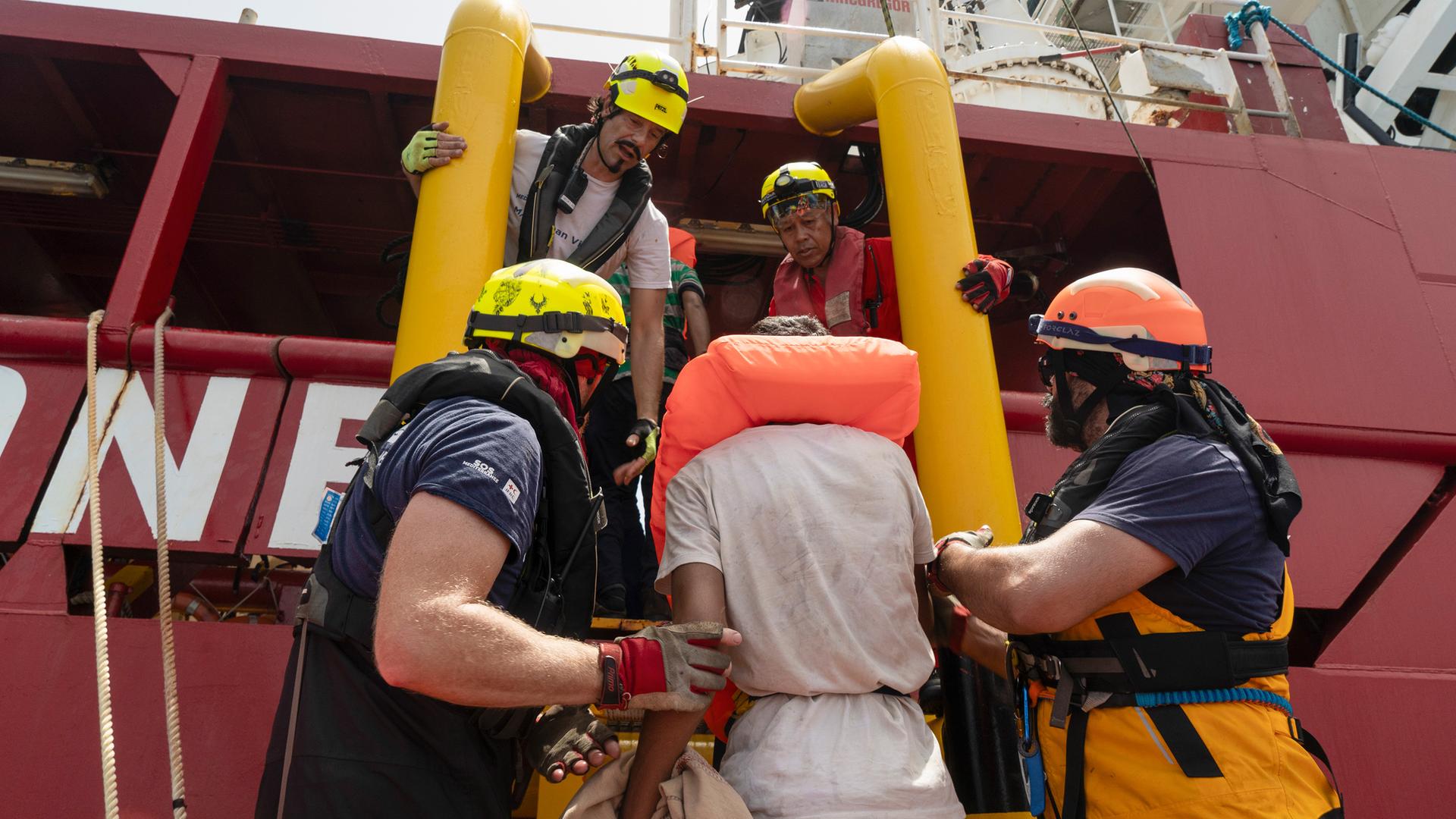 Retter von SOS Mediterranee helfen Migranten auf ihr Schiff