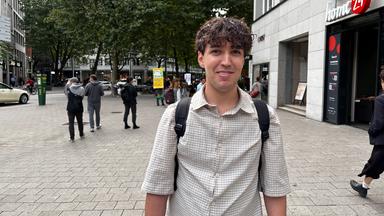 Mo-Luis steht lächelnd in der Hamburger Innenstadt.