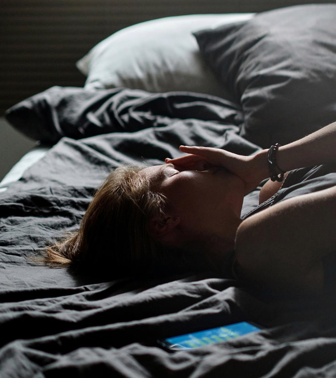 Weinende Teenagerin im Bett (Symbolfoto)