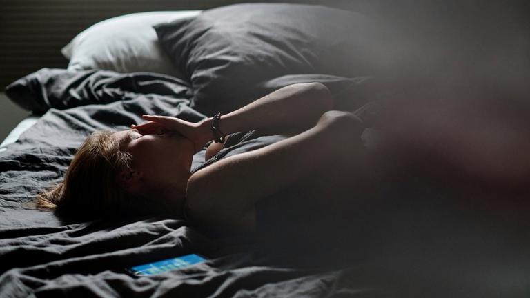 Weinende Teenagerin im Bett (Symbolfoto)