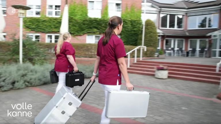 Zwei Frauen mit Koffern gehen zum Augencheck in ein Pflegeheim