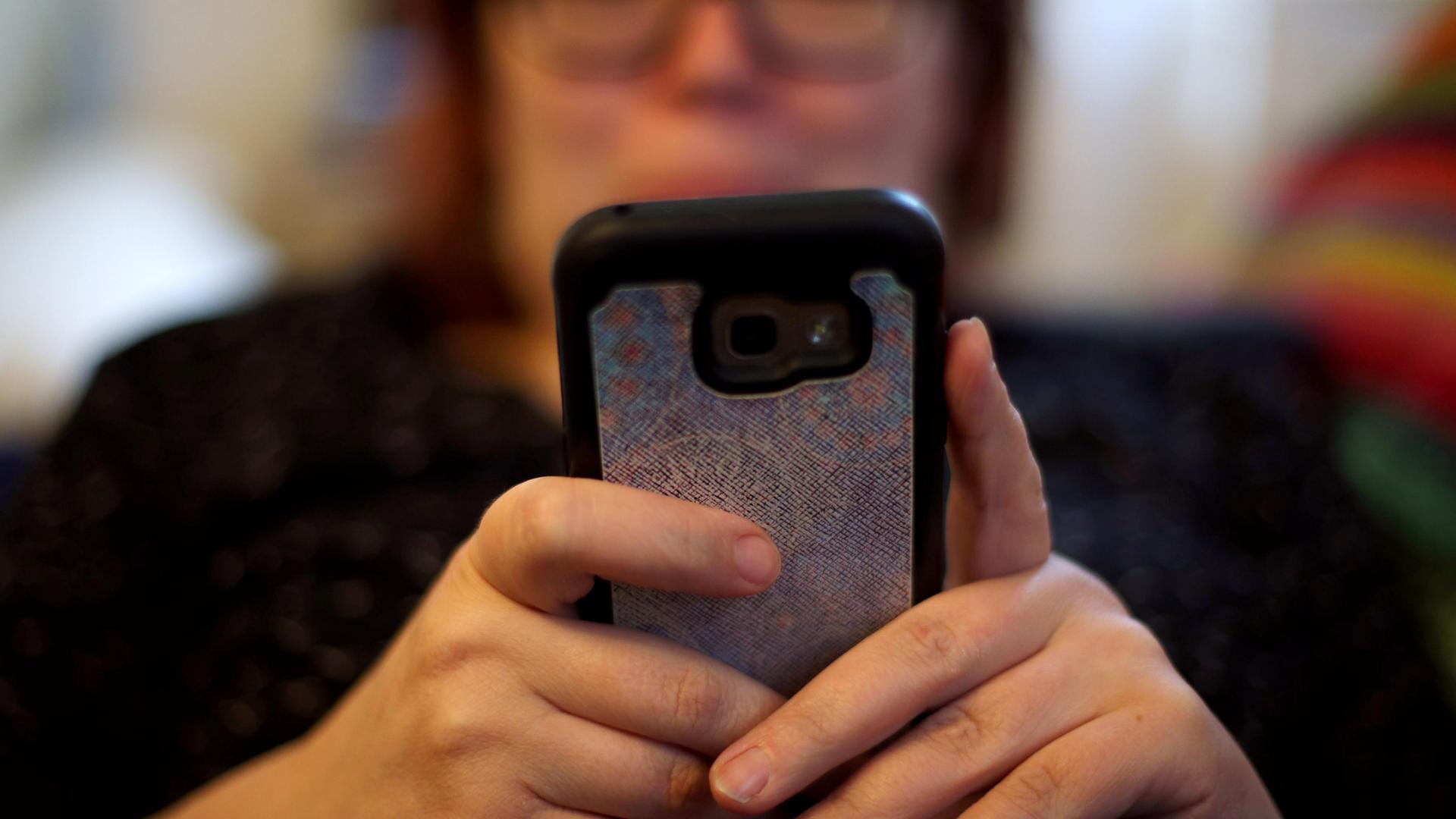 Eine Frau, die ihr Mobiltelefon benutzt.