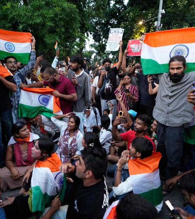 Eine Gruppe von Demonstranten in Neu-Delhi schwenkt indische Fahnen.