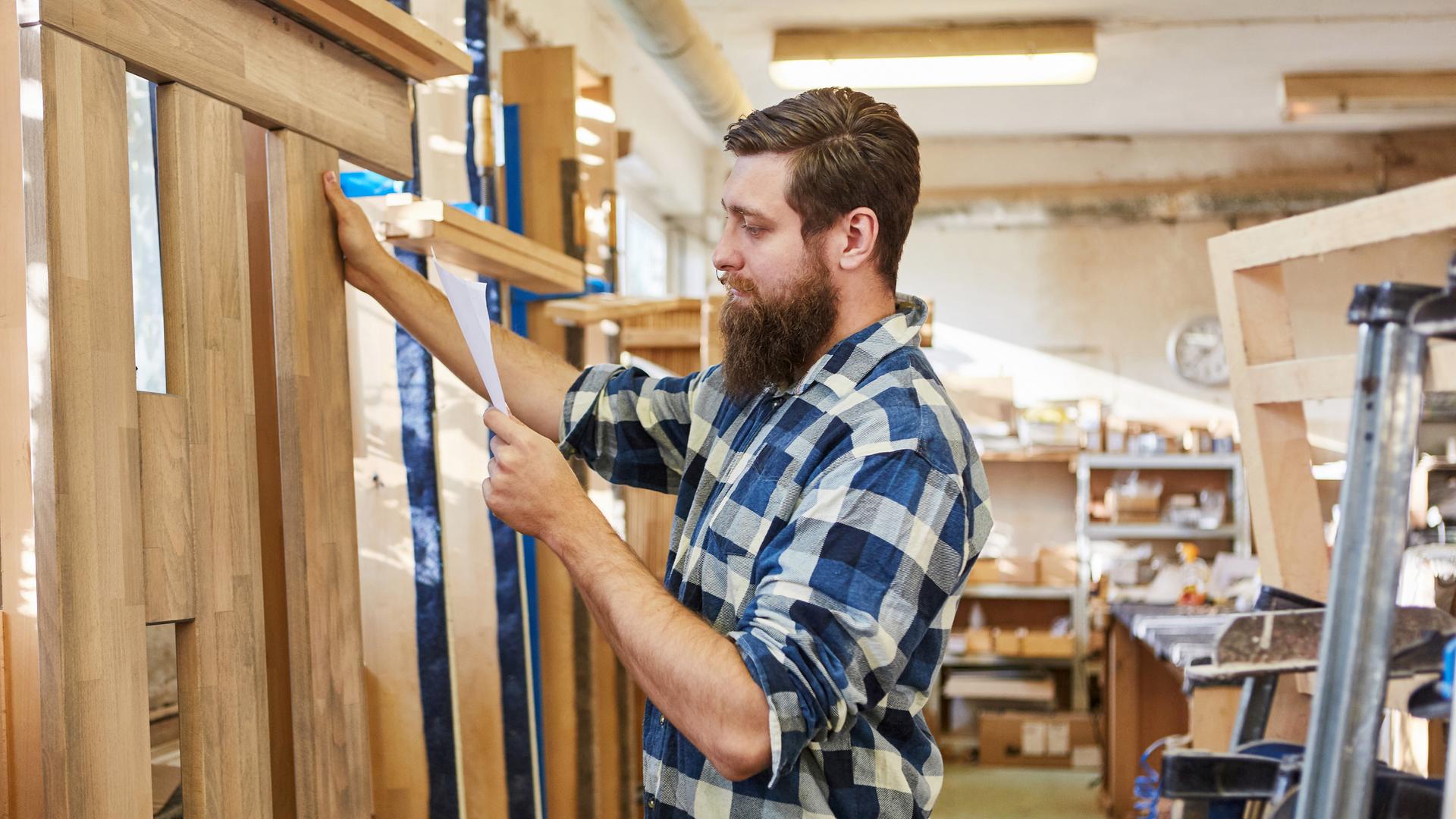 Möbelbauer kontrolliert Checkliste für Auftrag