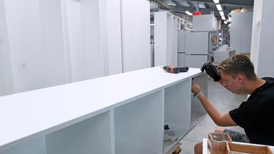 Ein Mitarbeiter montiert in der Möbelbau Sayda GmbH Schränke. 