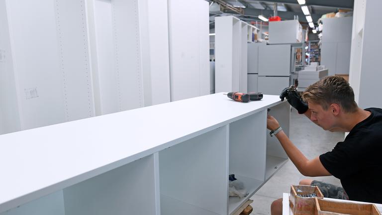 Ein Mitarbeiter montiert in der Möbelbau Sayda GmbH Schränke. 