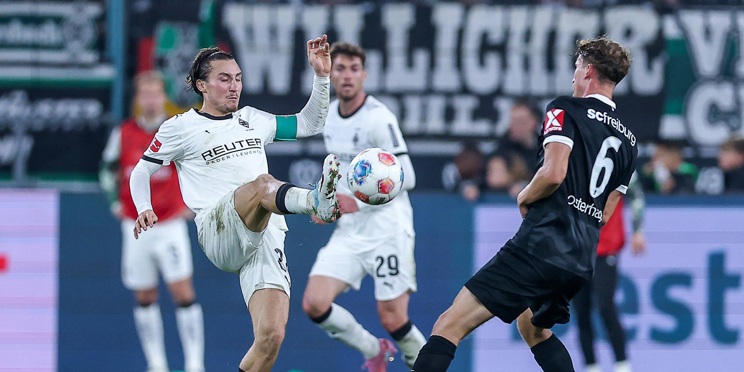 Rocco Reitz (Borussia Mönchengladbach 27) und Patrick Osterhage (SC Freiburg 06) kämpfen. 