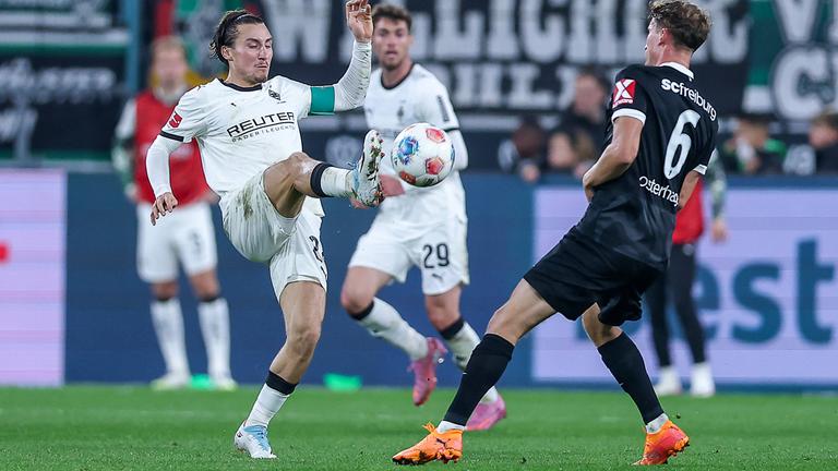 Rocco Reitz (Borussia Mönchengladbach 27) und Patrick Osterhage (SC Freiburg 06) kämpfen. 