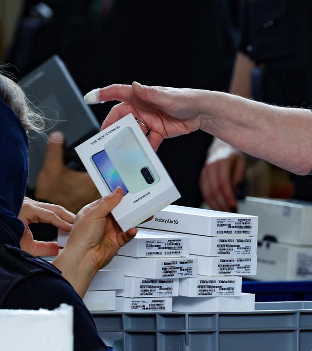 Mehrere Smartphones liegen verpackt auf einem Stapel.
