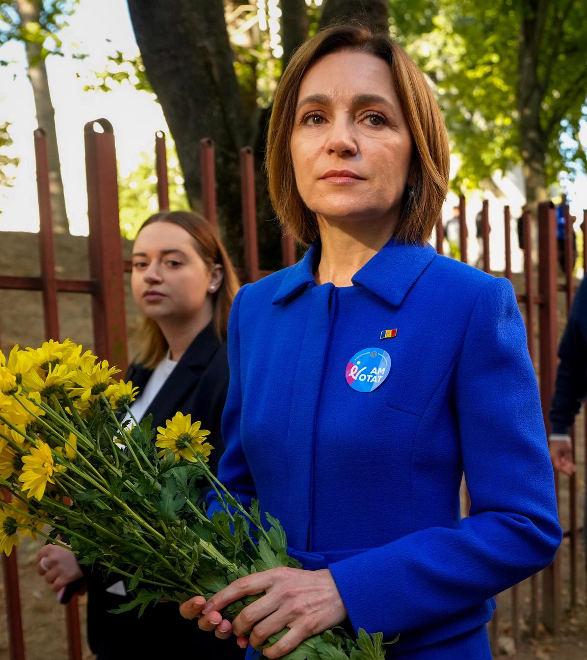 Moldaus Präsidentin Maia Sandu verlässt ein Wahllokal und hält dabei einen Blumenstrauß