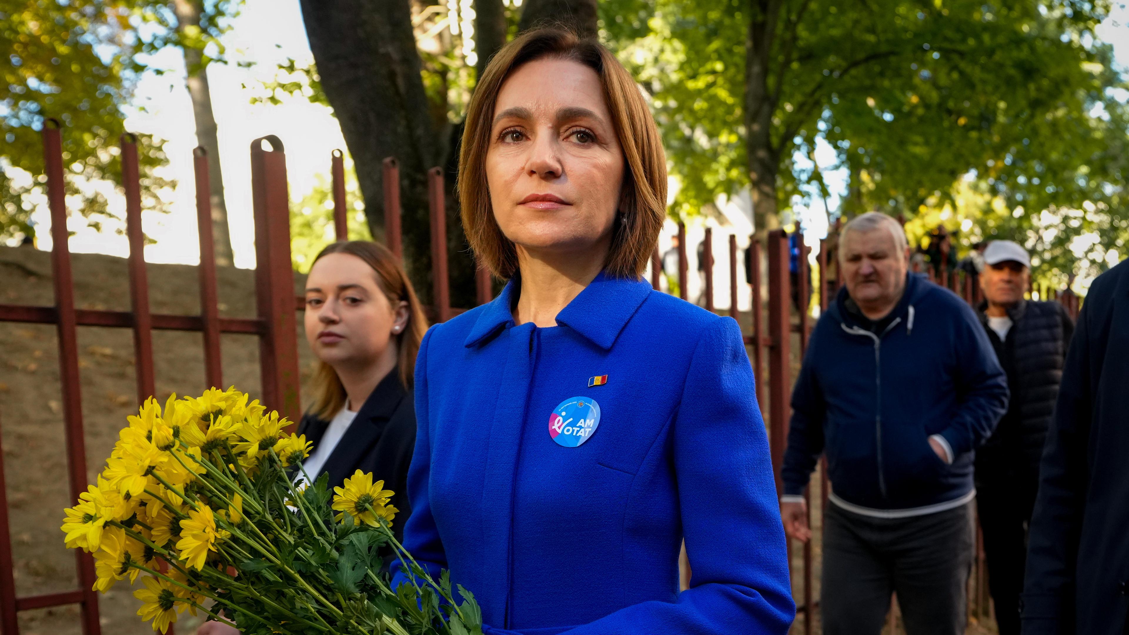 Moldaus Präsidentin Maia Sandu verlässt ein Wahllokal und hält dabei einen Blumenstrauß