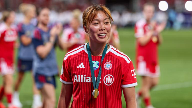 Momoko Tanikawa feiert nach dem Supercup der Frauen auf dem Rasen mit einer Medaille um den Hals. 