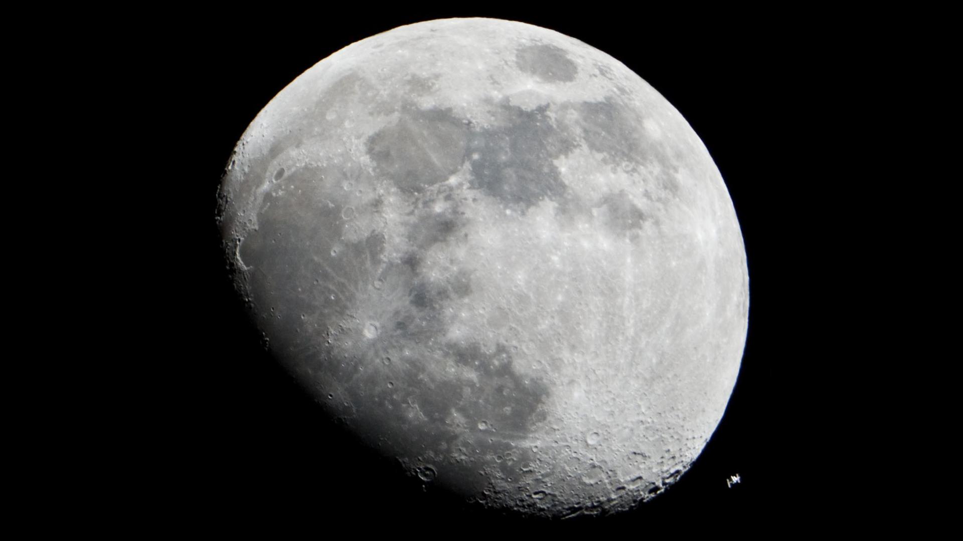 Der Mond und die internationale Raumstation ISS am nächtlichen Himmel.