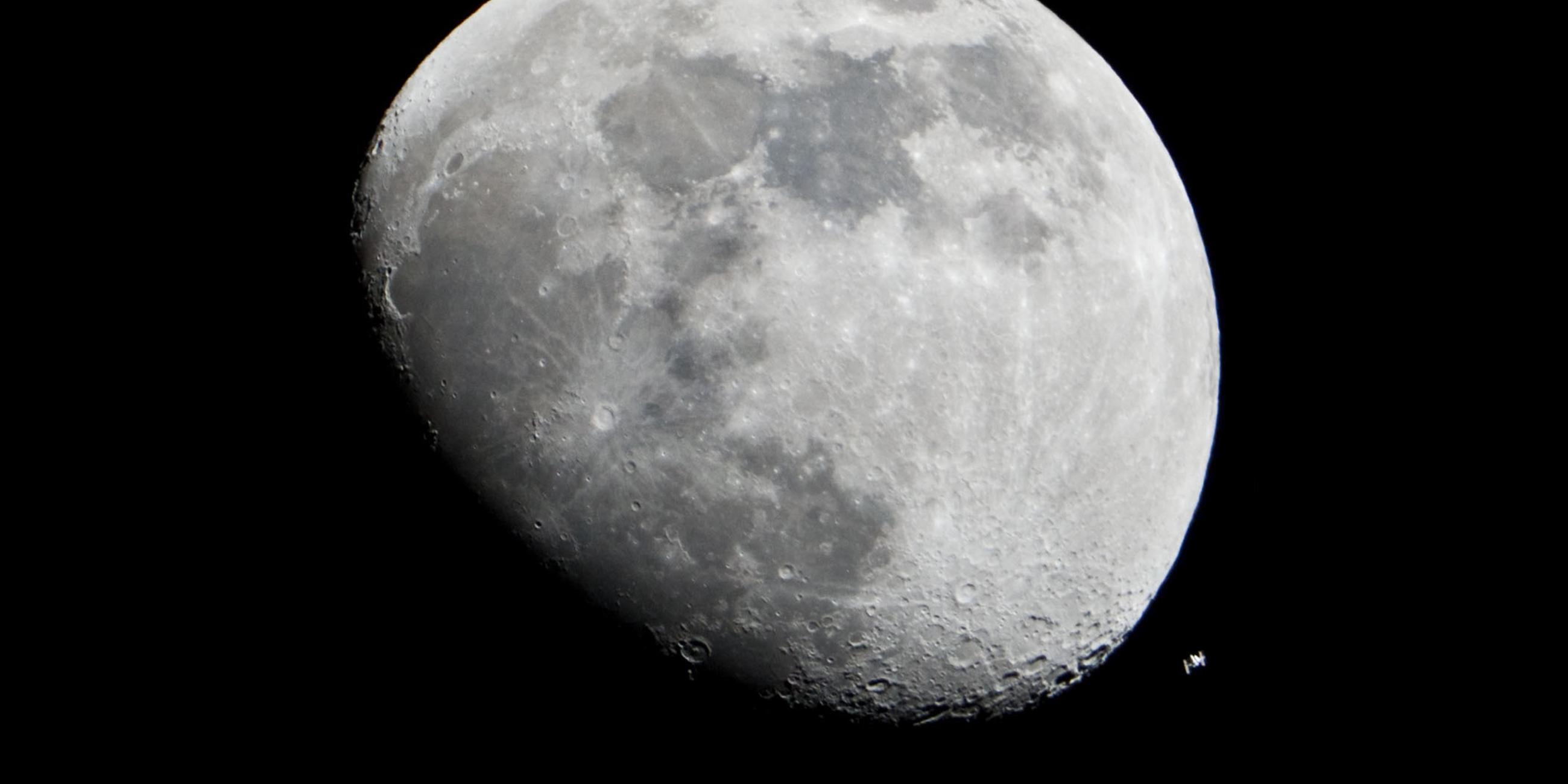 Der Mond und die internationale Raumstation ISS am nächtlichen Himmel.