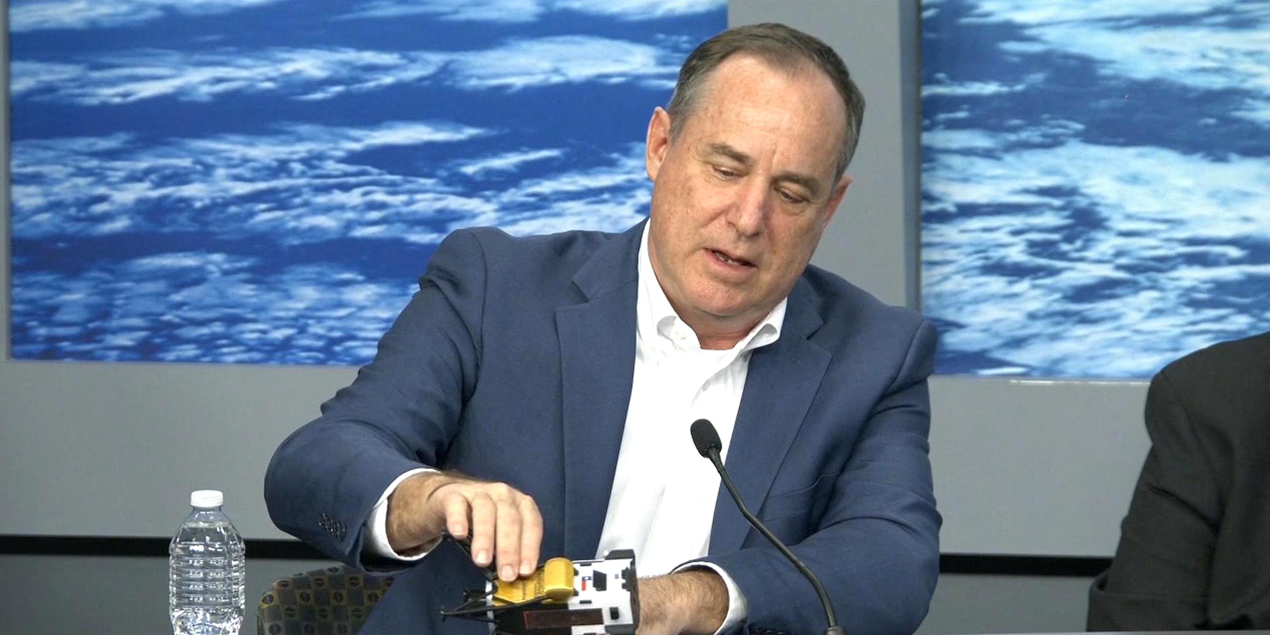 Steve Altemus zeigt mit einem Modell, wie das Landemodul Odysseus auf der Mondoberfläche liegt