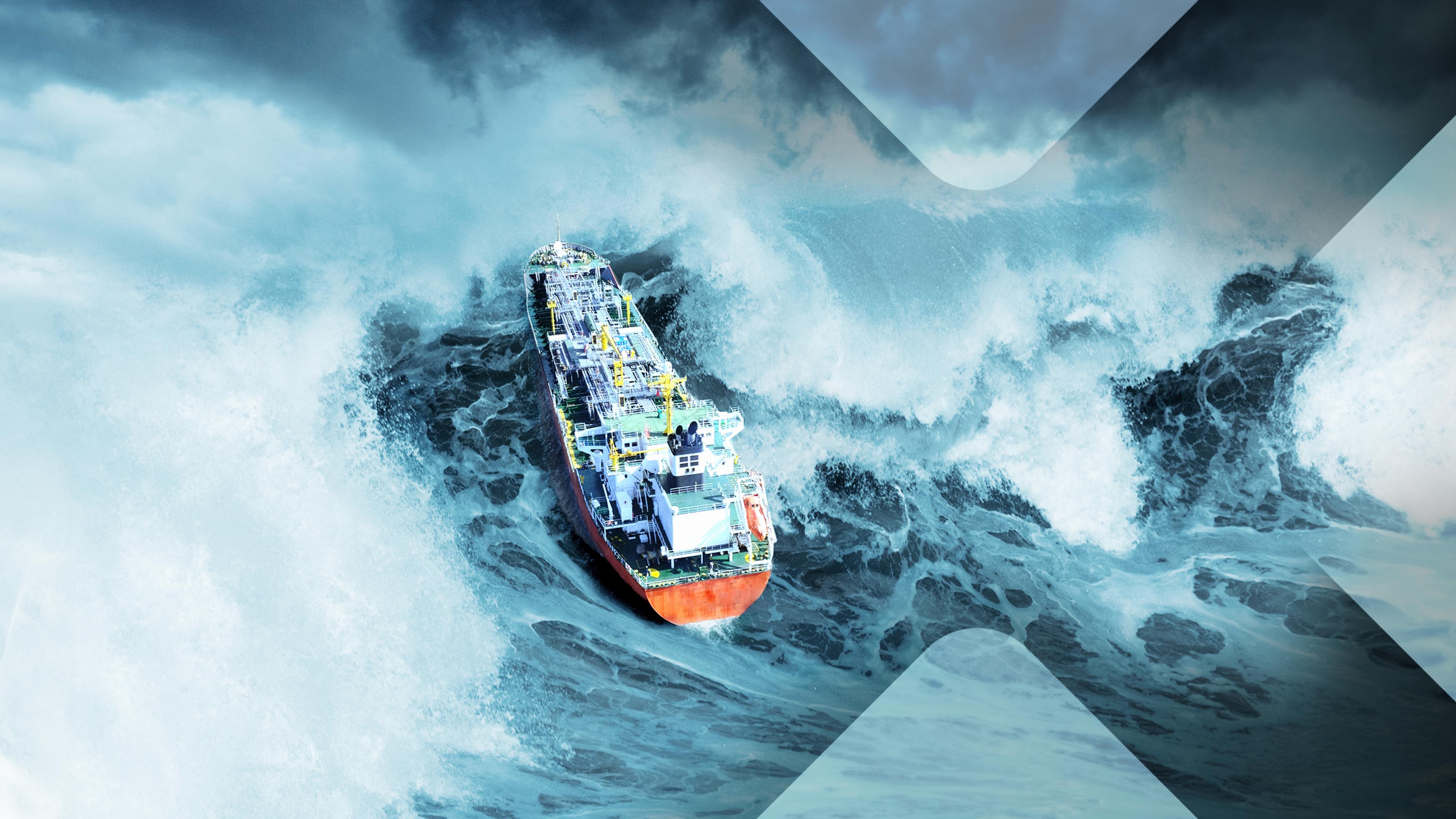 Ein Schiff auf dem Meer gerät durch eine hohe Welle von links in Schieflage.