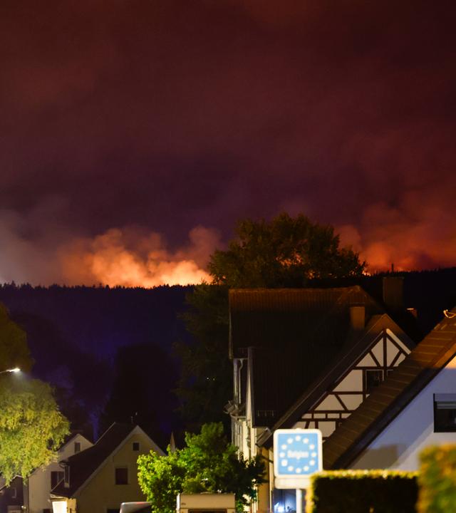  Blick von dem Ortsteil Monschau-Kalterherberg auf die belgische Seite, wo das Hohe Venn in Flammen steht.