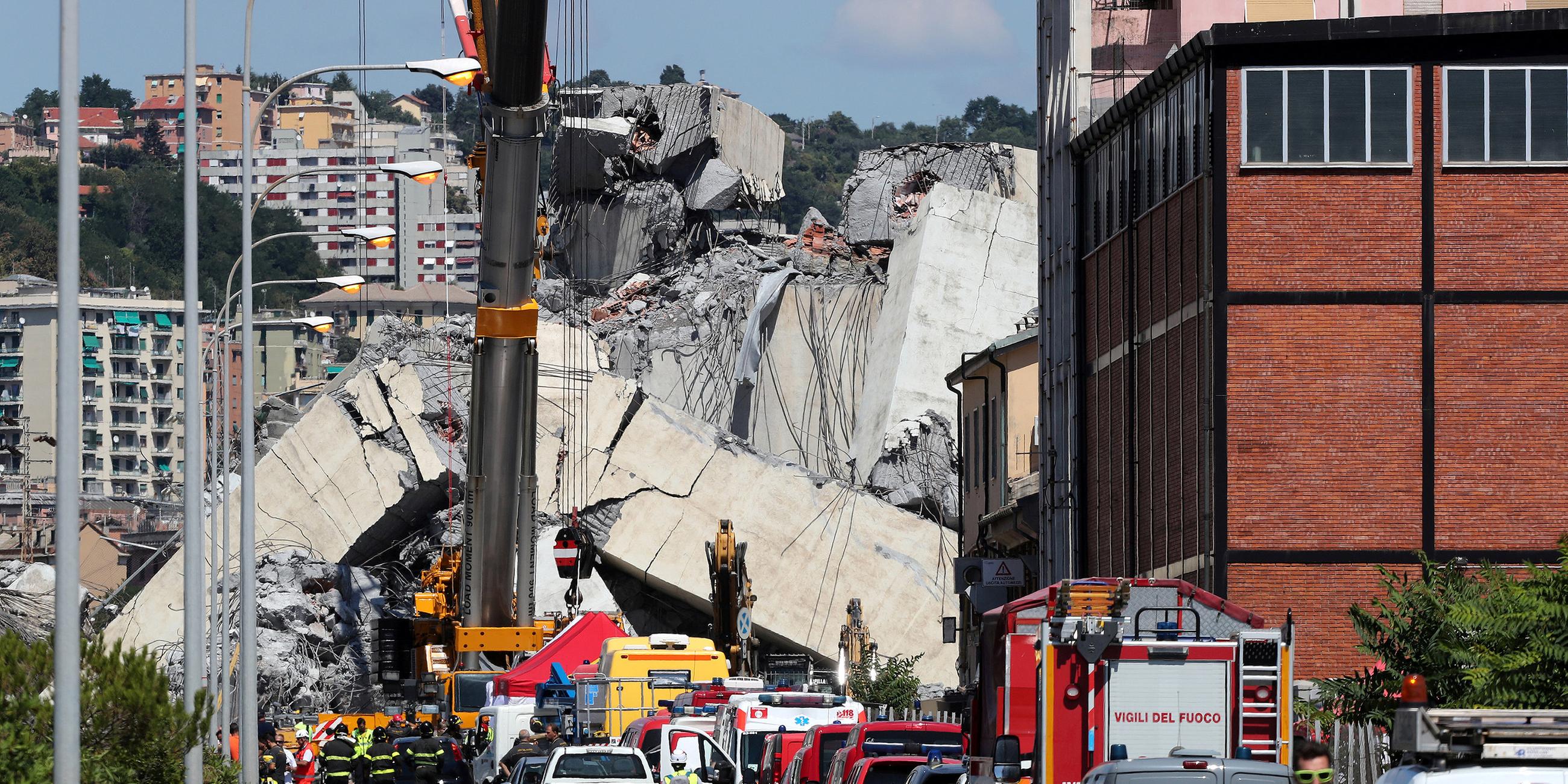 Feuerwehrmänner bei den Trümmern der Morandi-Brücke