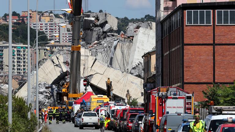 Feuerwehrmänner bei den Trümmern der Morandi-Brücke