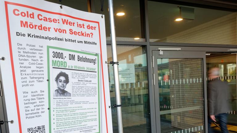 18.03.2023, Köln: Ein Mann betritt vor Beginn eines DNA Massentests das Gebäude, vor dessen Tür ein Fahndungsplakat steht. Die 16-jährige Seckin Caglar wurde 1991 getötet.