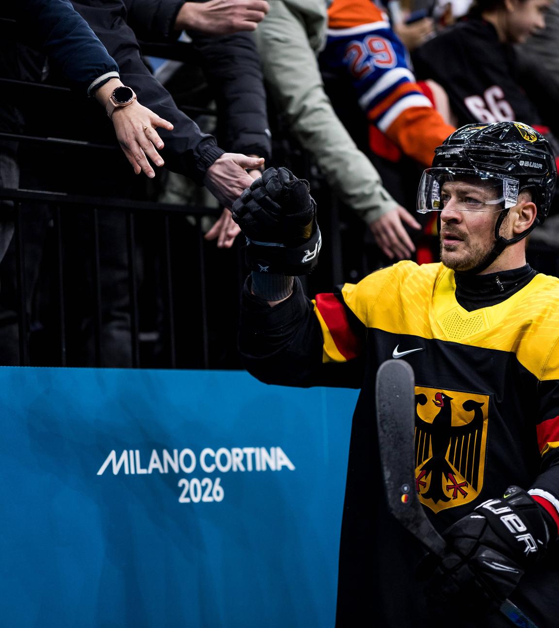 Moritz Müller klatscht vor dem Vorrundenspiel gegen die USA bei den Milano Cortina 2026 Olympics mit Fans ab.