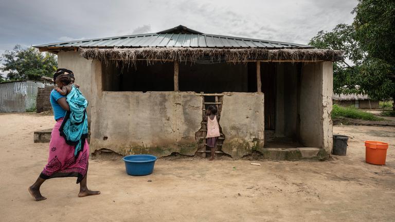 Mosambik, Cabo Delgado: Mutter mit Kind vor Haus