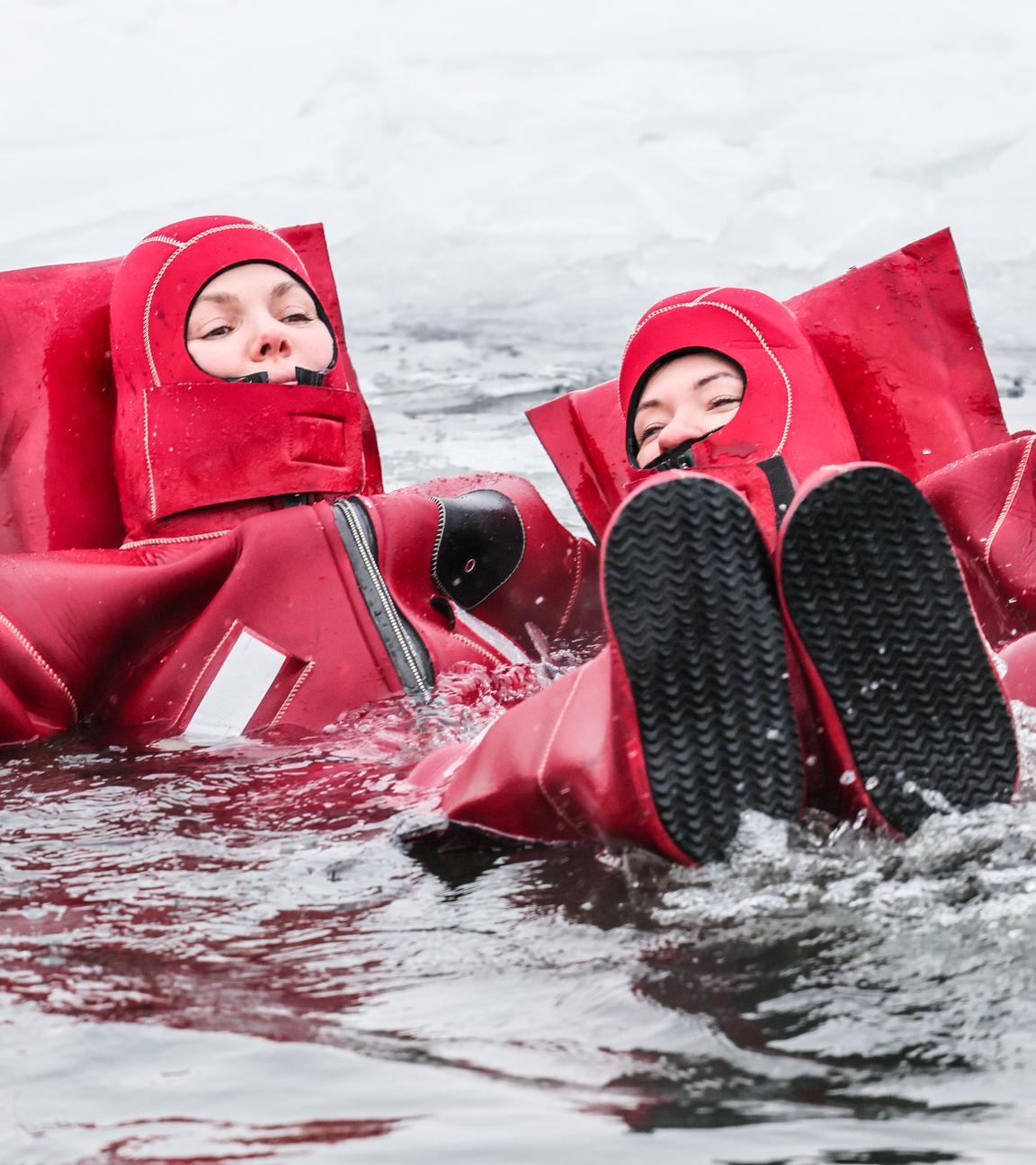  Menschen in Neoprenanzügen genießen im Winter die Freizeitaktivität des Eisschwimmens auf dem Fluss Moskwa. 