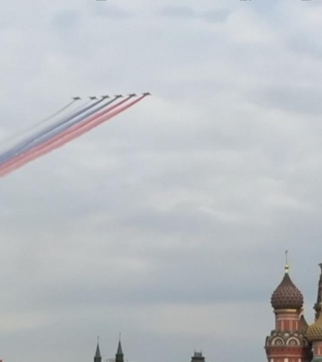 Flugzeuge verteilen bunte Farbe im Himmel über den Dächern von Moskau