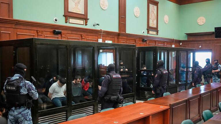 Angeklagte sitzen vor einer Anhörung vor dem 2. Militärgericht des westlichen Bezirks in Moskau, Russland, in mehreren Glaszellen.