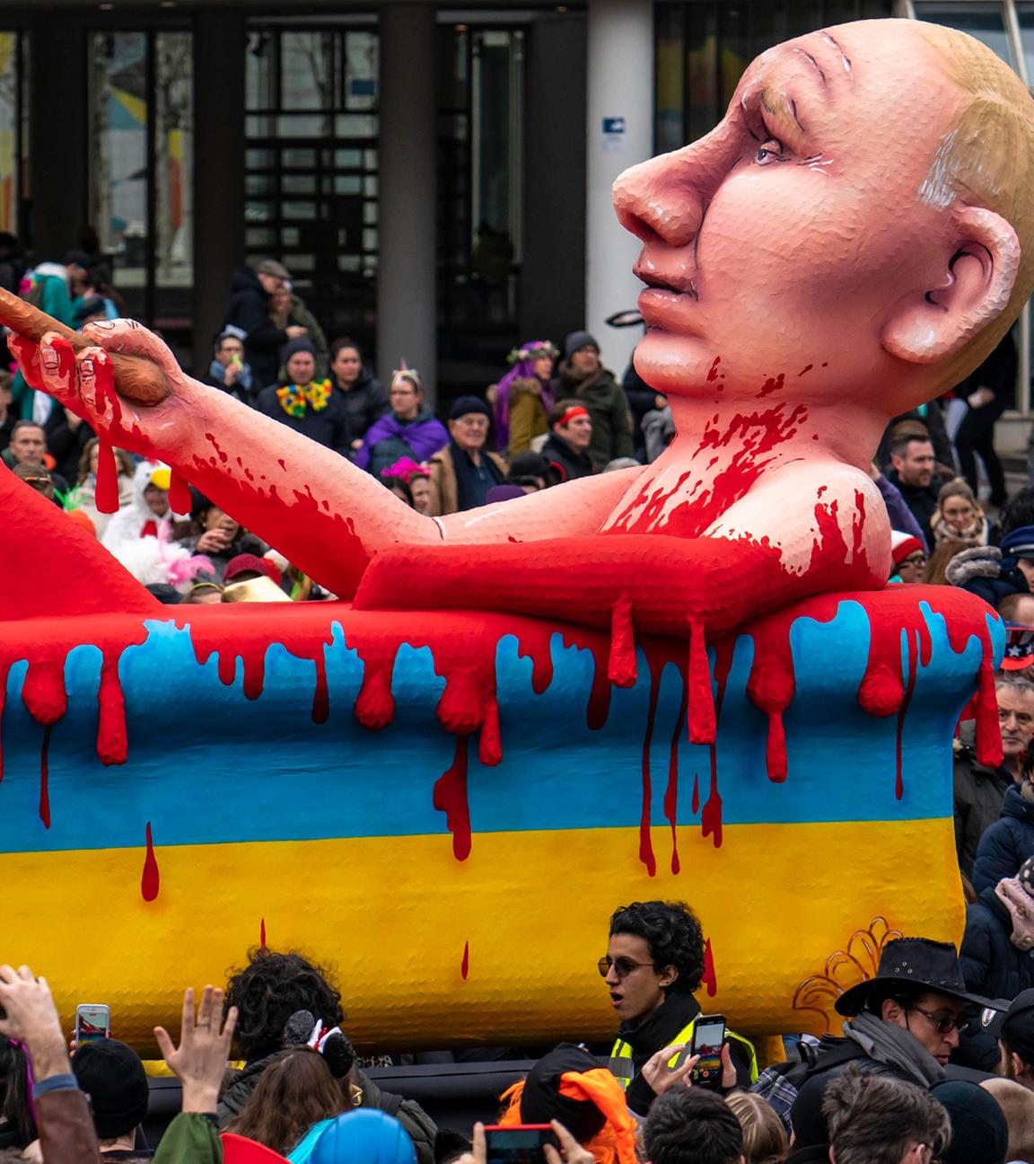 Wladimir Putin nimmt auf einem Motivwagen des Düsseldorfer Rosenmontagsumzuges ein Blutbad als Fastnachtsfigur am 20.02.2023.
