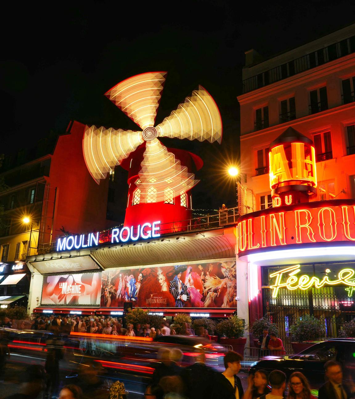 Dieses Bild mit Langzeitbelichtung zeigt die neuen Flügel der Windmühle des Moulin Rouge, die sich drehen, während das Kabarett in Paris seine Wiederinbetriebnahme feiert. 