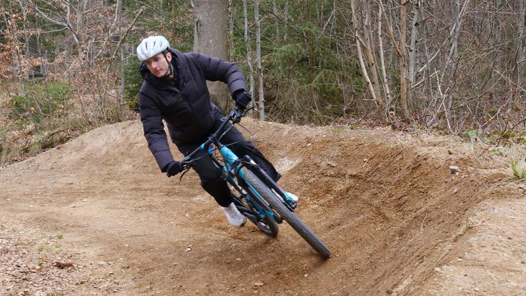 Ein Mountainbiker fährt auf seinem Fahrrad einen Waldweg entlang.
