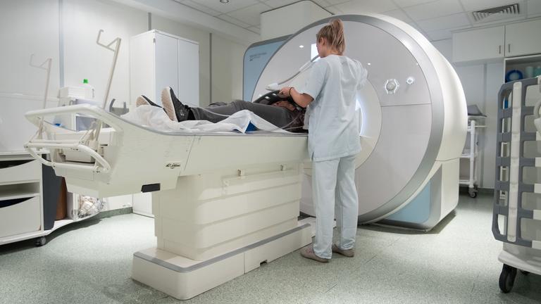 Ein Frau liegt in der Radiologie in einem Gerät zur Magnetresonanztomographie.