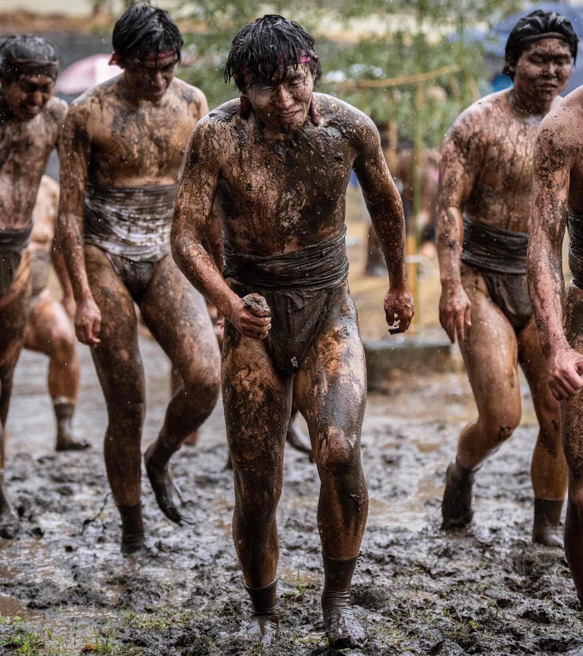 Teilnehmer verlassen ein schlammiges Feld