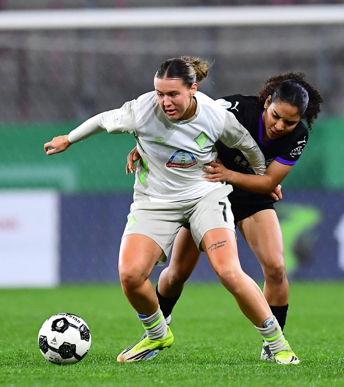 Bremens Stürmerin Larissa Michelle Mühlhaus wird von hinten im Zweikampf von Essens Verteidigerin Ella Touon bedrängt