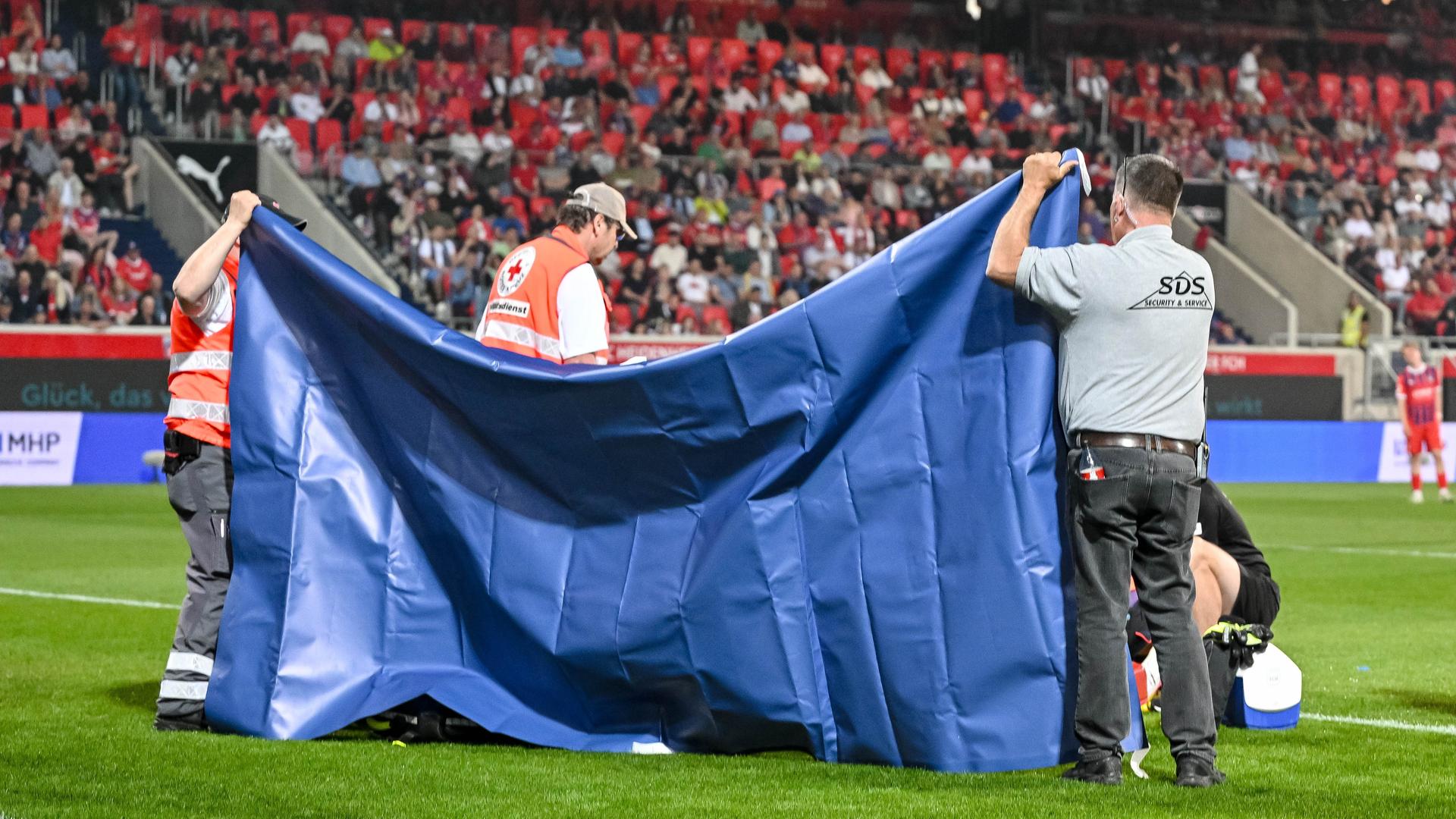Heidenheims Torwart Kevin Müller wird nach einem Zusammenstoß behandelt.