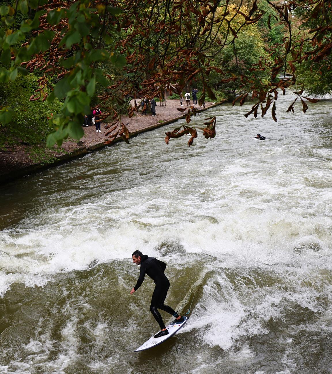 Ein Mann surft im Eisbach im Englischen Garten in München, Archivbild