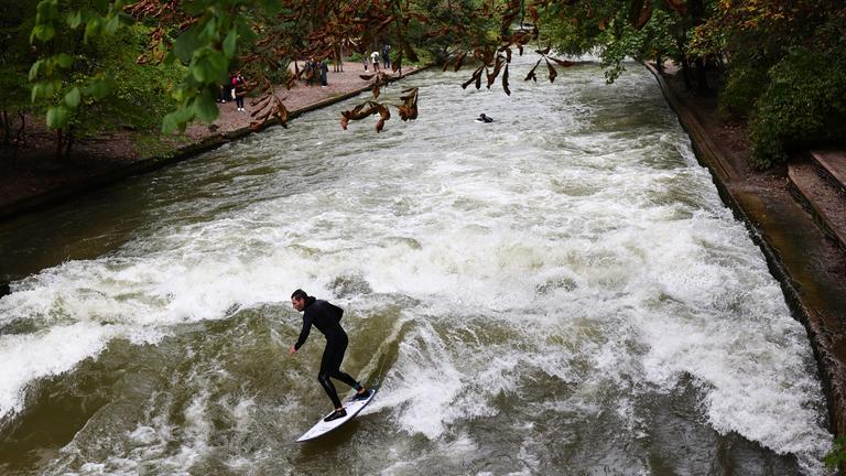 Ein Mann surft im Eisbach im Englischen Garten in München, Archivbild