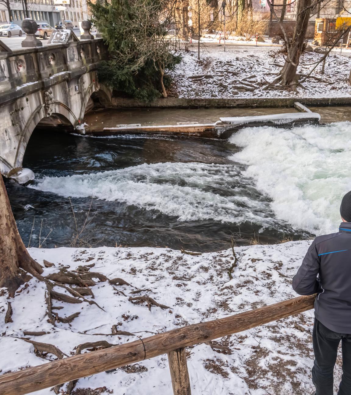 Man sieht die Münchner Eisbachwelle im Winter