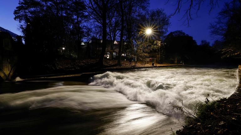 Zu sehen ist die berühmte Eisbachwelle bei Nacht, welche nach Aufräumarbeiten abgeflacht ist.