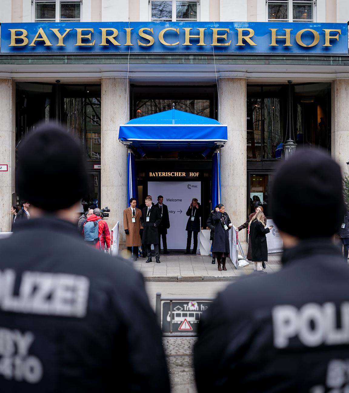 Zwei Polizisten stehen mit einigem Abstand vor dem Hotel "Bayerischer Hof".