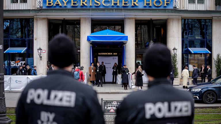 Zwei Polizisten stehen mit einigem Abstand vor dem Hotel "Bayerischer Hof".