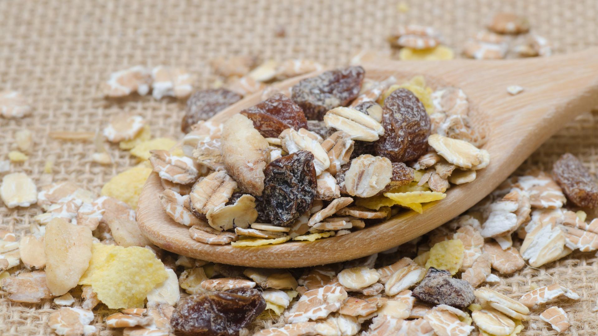 Auf einem Holzlöffel ist Früchtemüsli zu sehen.