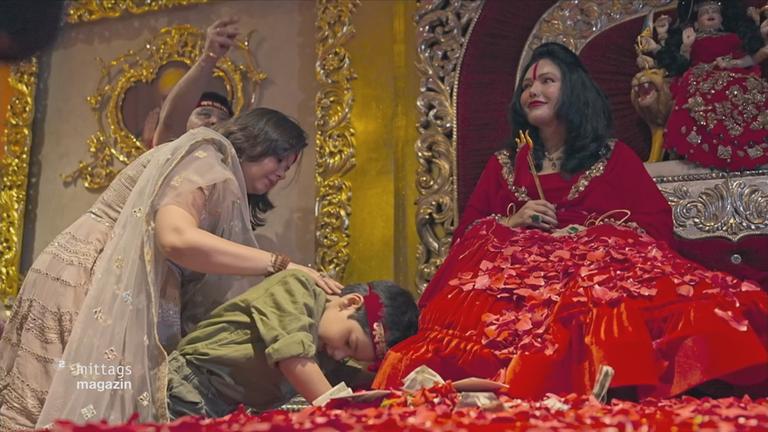 Frauen in Kleidern sitzen in einem festlichen Raum