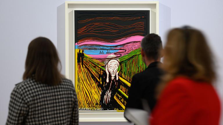 Im Hintergrund hängt an der Wand eine Neuinterpretation des Werks "Der Schrei". Im Vordergrund sind verschwommen Besucher zu sehen.