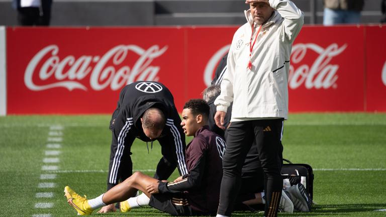 Hessen, Frankfurt/Main: Fußball: Nationalmannschaft, Deutschland, Nations League, vor den Spielen gegen Ungarn und England, Training, DFB-Campus: Bundestrainer Hansi Flick (r) steht vor Jamal Musiala (M), der von Ärzten betreut wird. 