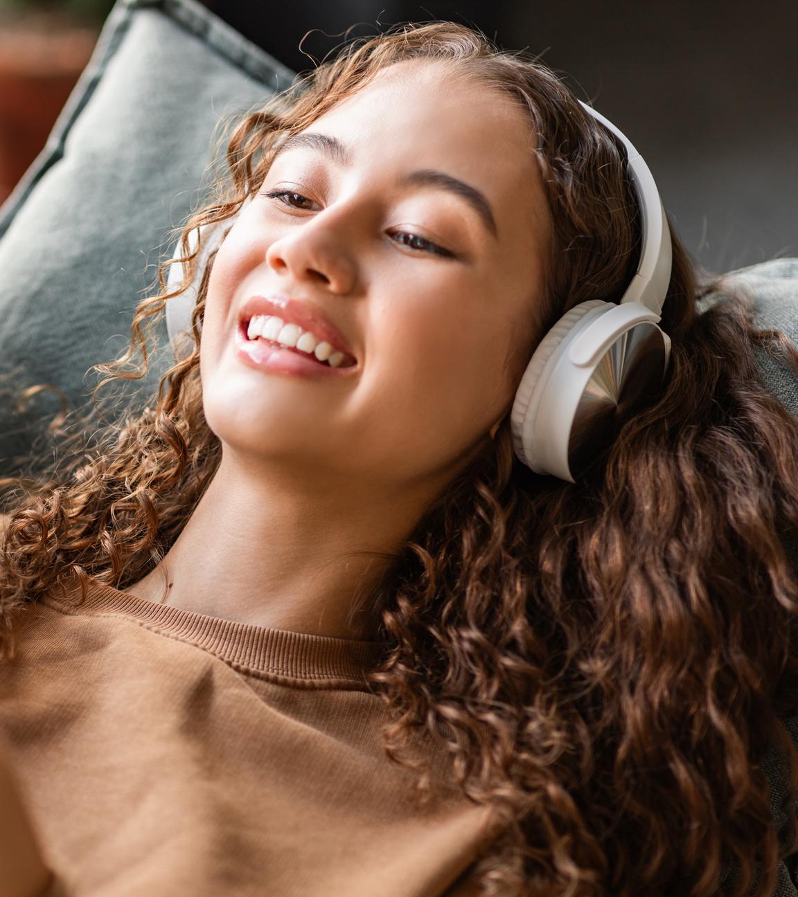Eine junge Frau hört mit Kopfhörer Musik