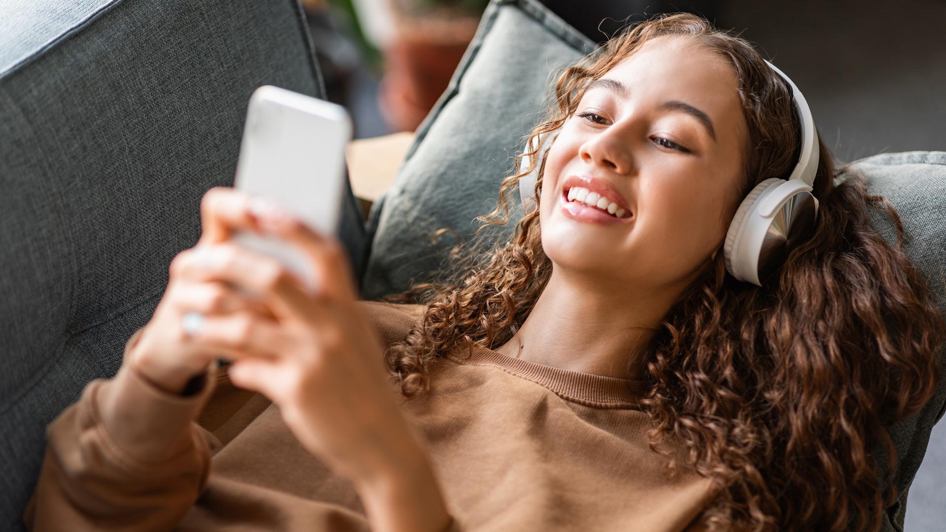 Eine junge Frau hört mit Kopfhörer Musik